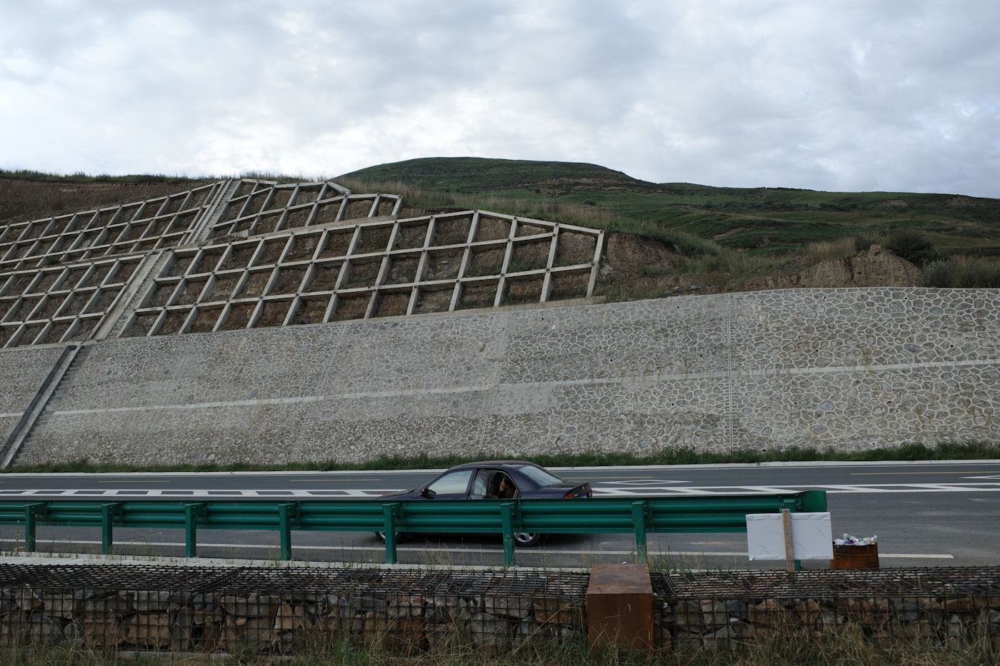Engineered retaining wall along a graded roadway