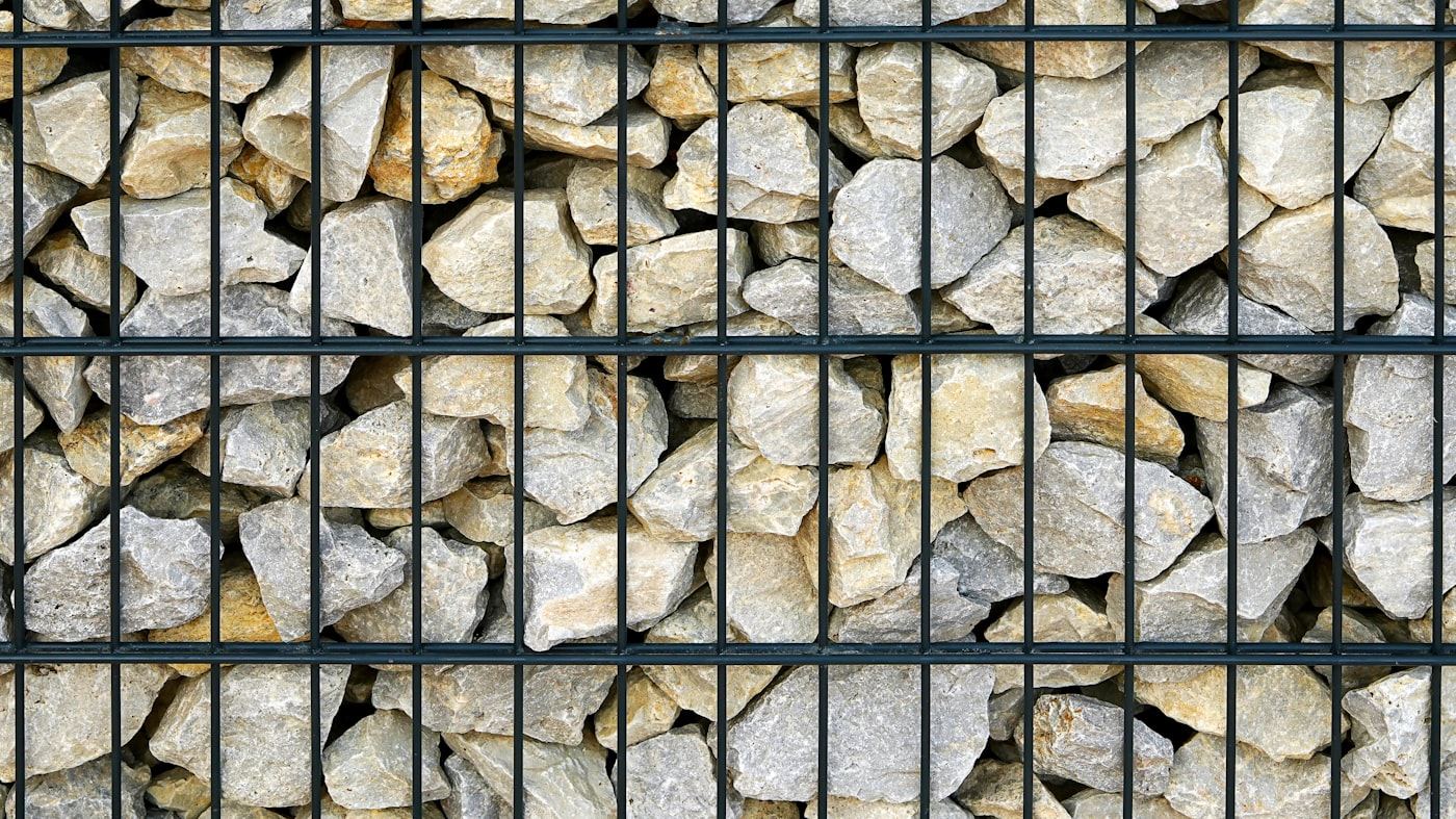 Gabion-style drainage wall filled with rock